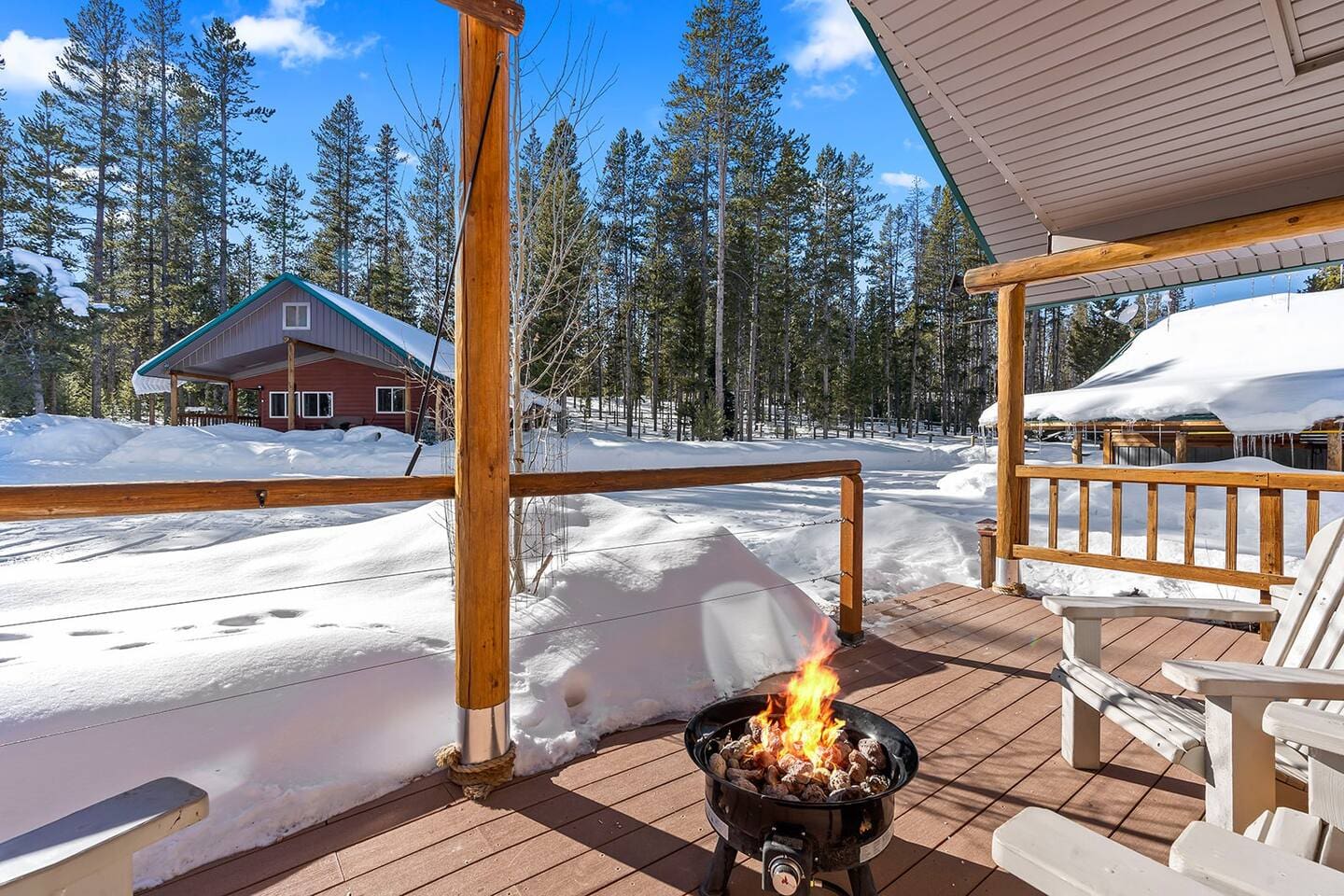Snowy winter view from the covered porch at Valley Creek Cabin with outdoor fire pit.
