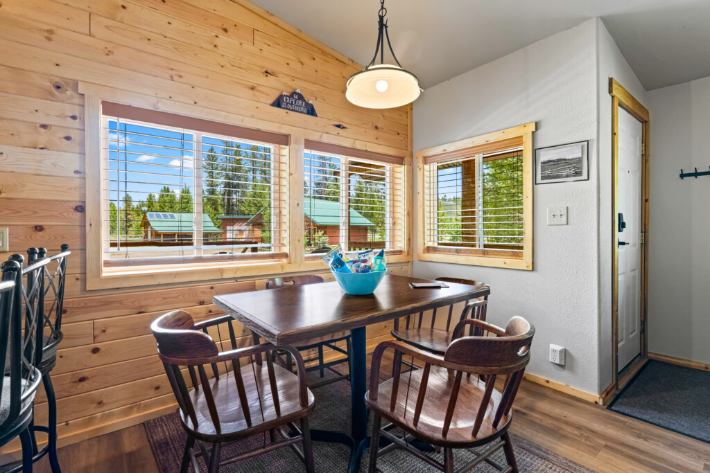 Dining area at Ponderosa Pine Cabin with table and large windows overlooking the trees.