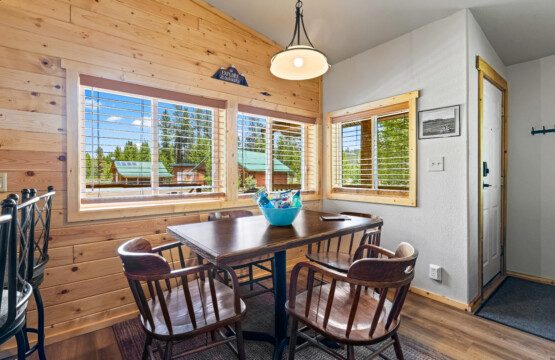 Dining area at Ponderosa Pine Cabin with table and large windows overlooking the trees.