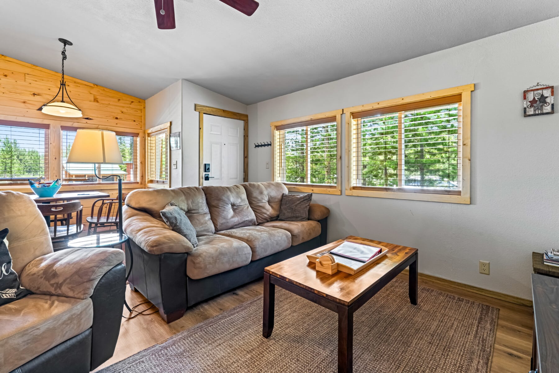 Bright living area at Ponderosa Pine Cabin with sofa, coffee table and large windows.