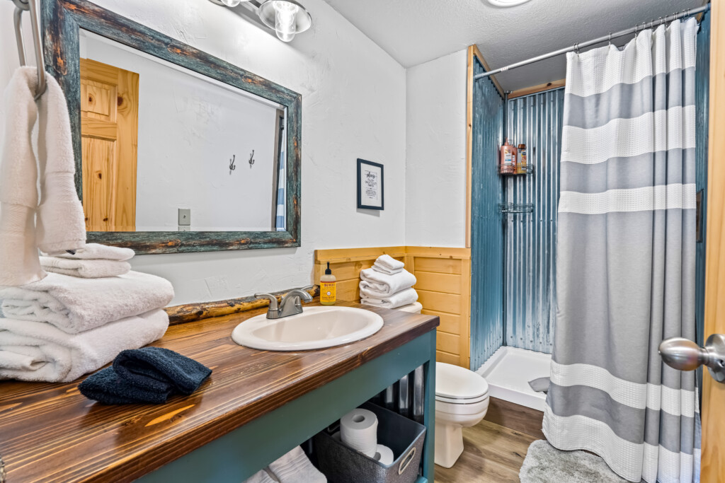 Bathroom at Ponderosa Pine Cabin with vanity, mirror and shower.