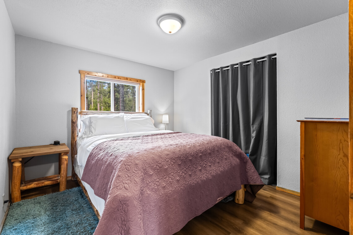 Primary bedroom at Ponderosa Pine Cabin with comfortable bed and natural light.