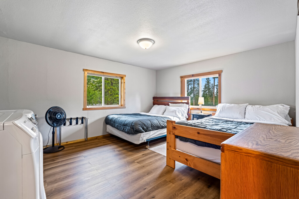 Second bedroom at Ponderosa Pine Cabin with two beds and wood flooring.