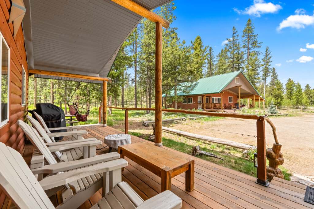 View from the covered porch at Ponderosa Pine Cabin overlooking the wooded property.