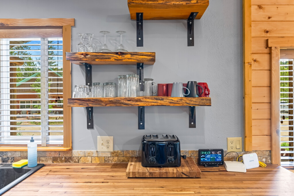 Bonanza Cabin kitchen shelves with glasses, mugs and toaster.