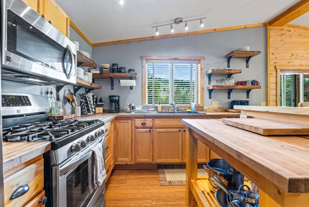 Full kitchen at Bonanza Cabin with wood cabinetry, island and stainless-steel appliances.