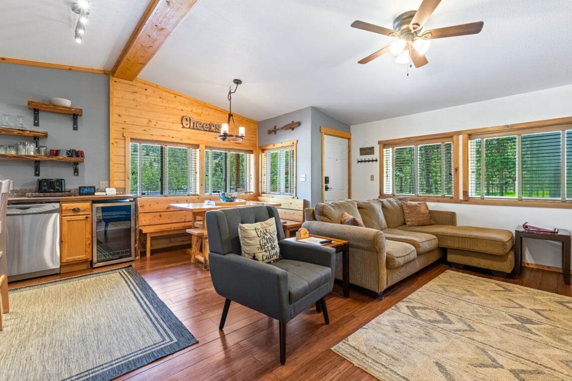 Bright living room at Bonanza Cabin with sectional sofa and large windows.