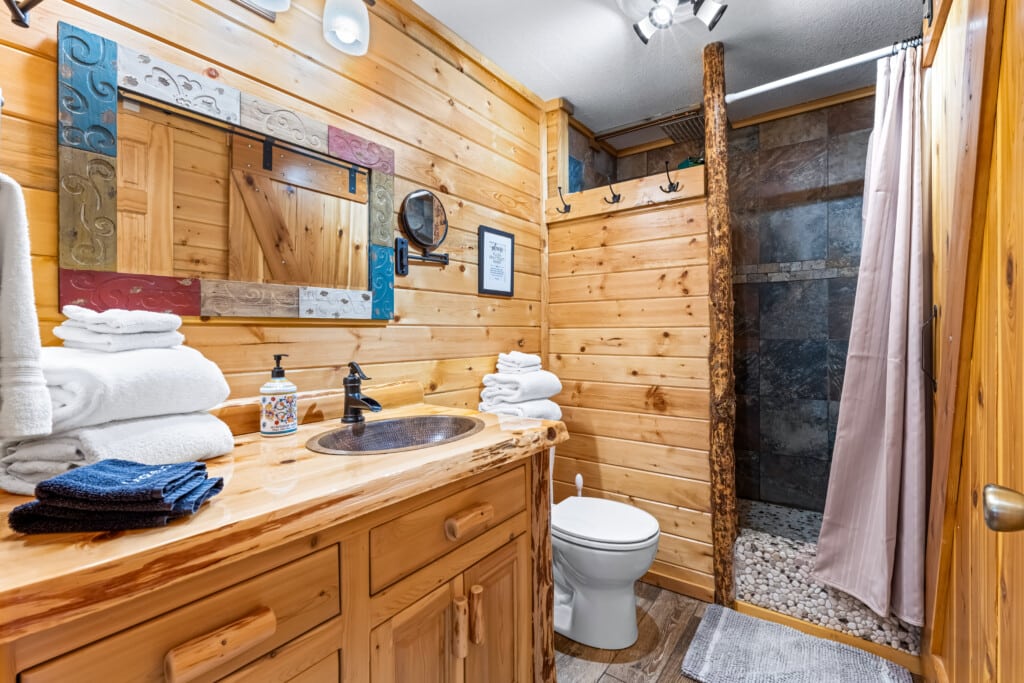 Bathroom at Bonanza Cabin with wood vanity and walk-in shower.