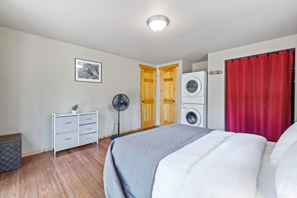 Bonanza Cabin bedroom with comfortable bed, dresser and in-room washer and dryer.