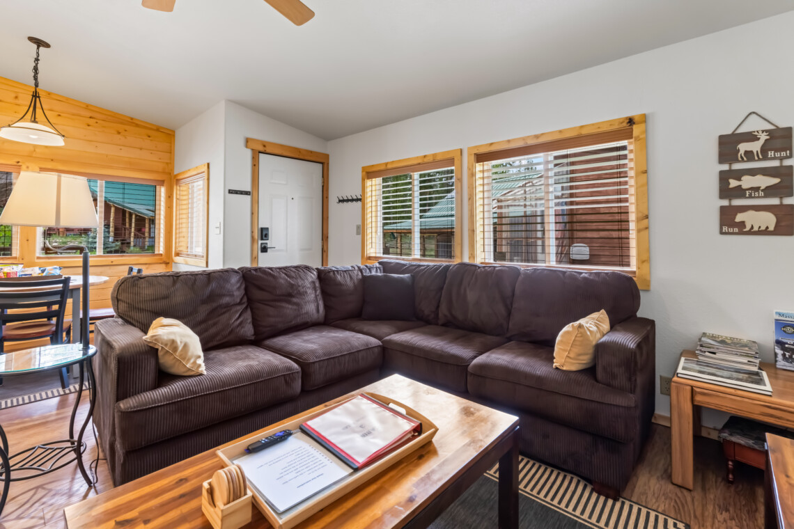 Valley Creek Cabin living room with sectional sofa and large windows.