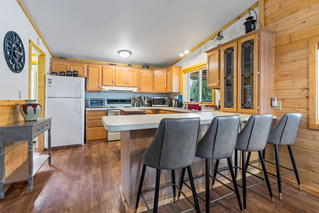 Valley Creek Cabin kitchen with breakfast bar seating and wood cabinets.