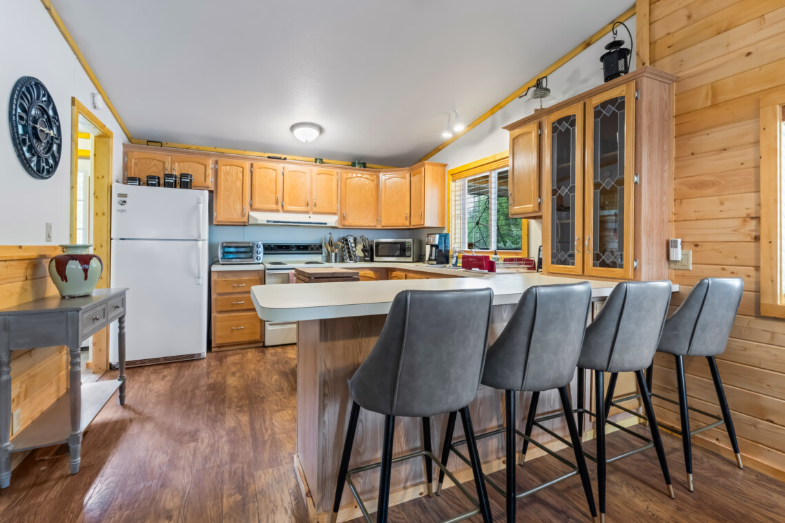 Valley Creek Cabin kitchen with breakfast bar seating and wood cabinets.