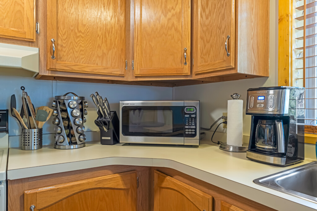 Kitchen coffee station at Valley Creek Cabin with microwave, coffee maker and supplies.