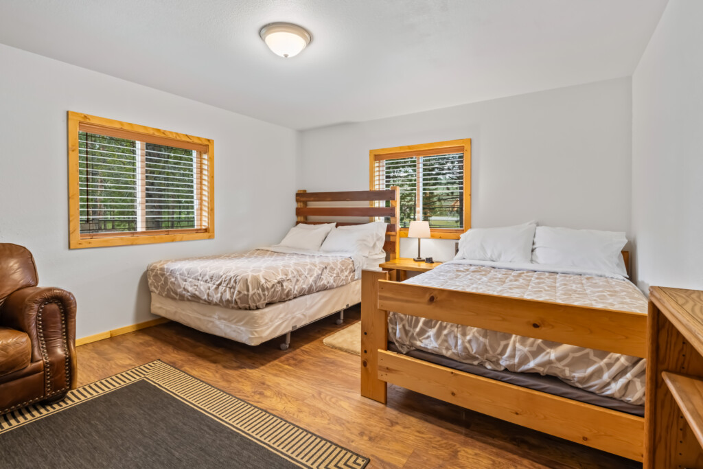 Second bedroom at Valley Creek Cabin with multiple beds and wood flooring.